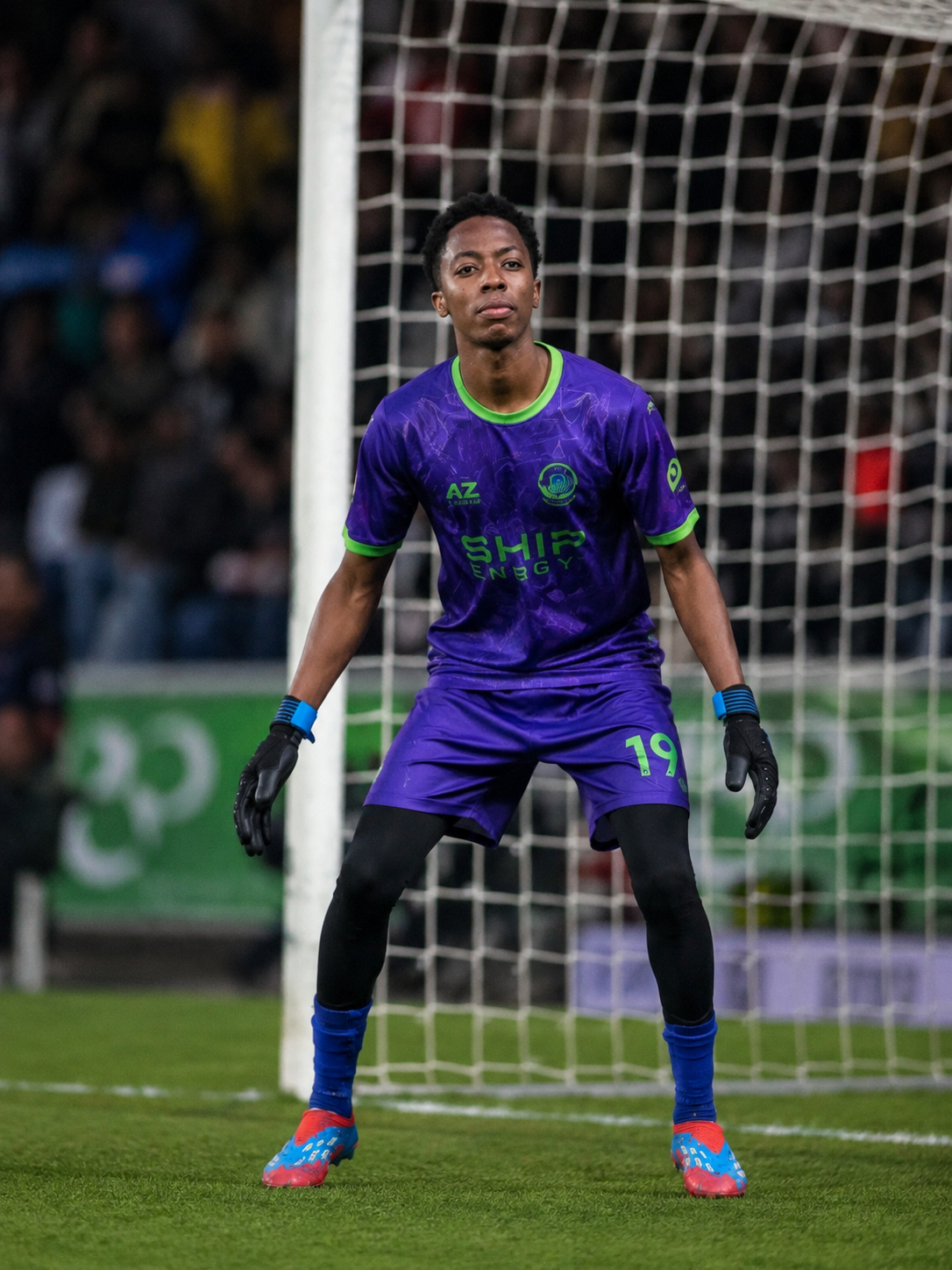 Akram Bulega in goalkeeper kit and gloves set in front of the goal